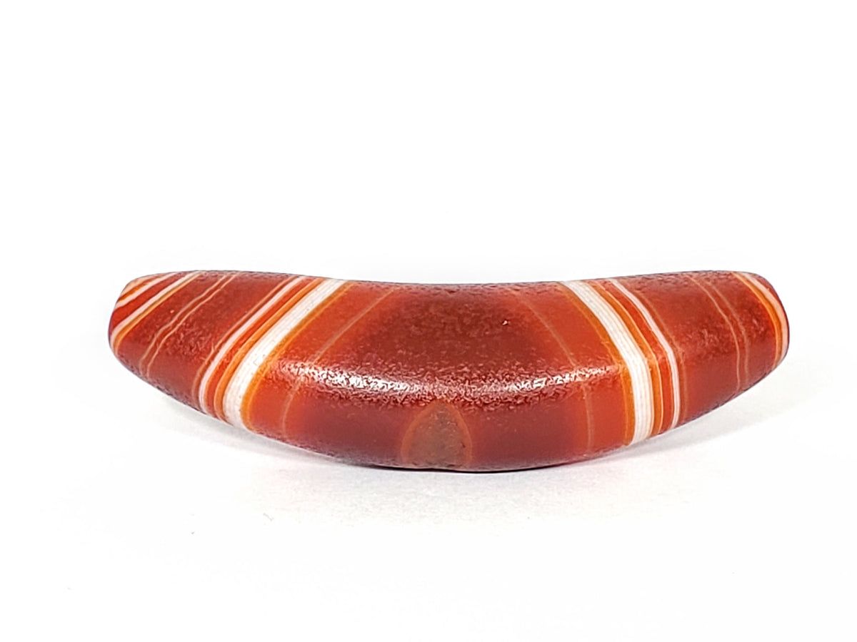 Bow-shaped natural banded agate dzi bead with red and white striped pattern, polished surface