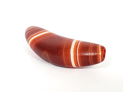 Bow-shaped natural banded agate dzi bead with white striping and reddish-brown coloring