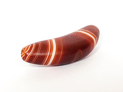 Bow-shaped natural banded agate dzi bead with white stripes and reddish-brown bands, polished surface
