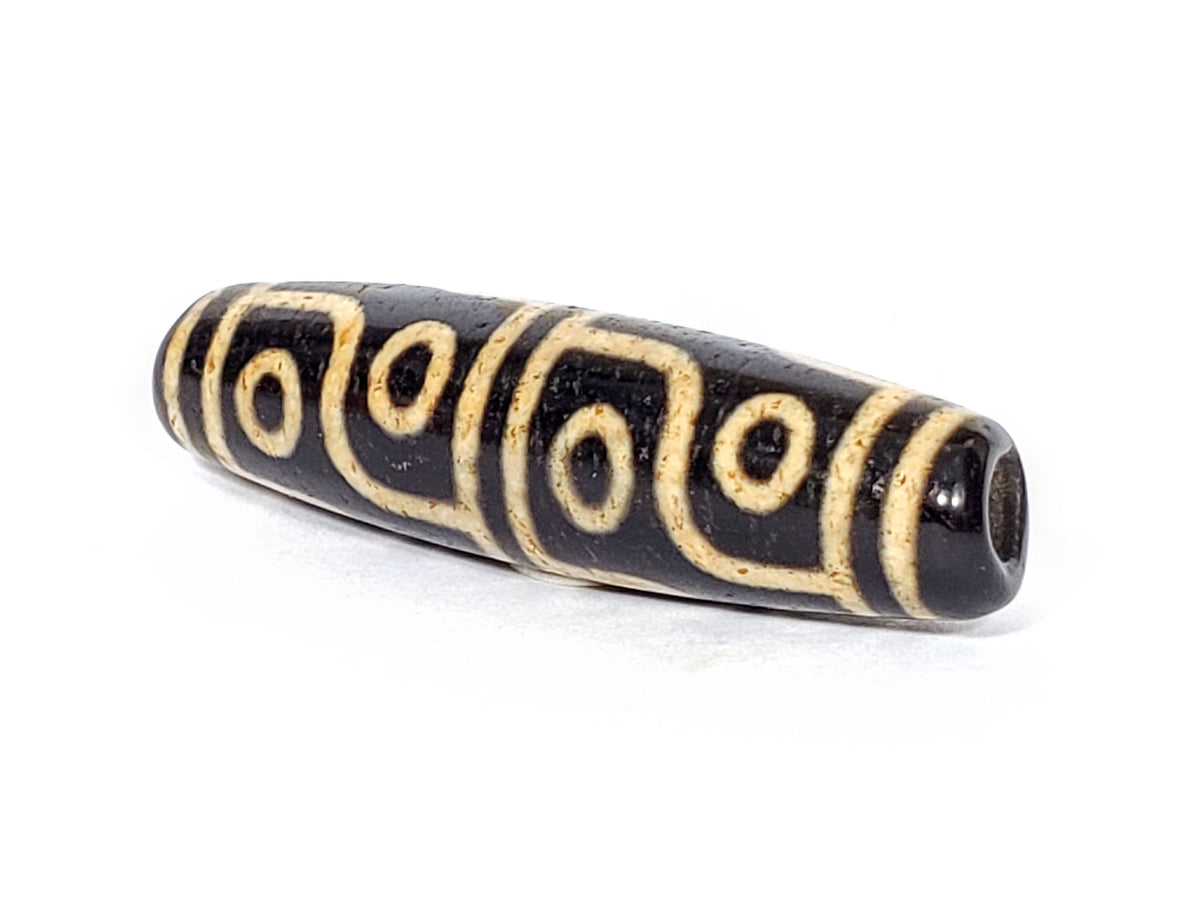 V-FA-062126-12E-LK dzi bead, angled view showing large keyhole drill hole, unretouched