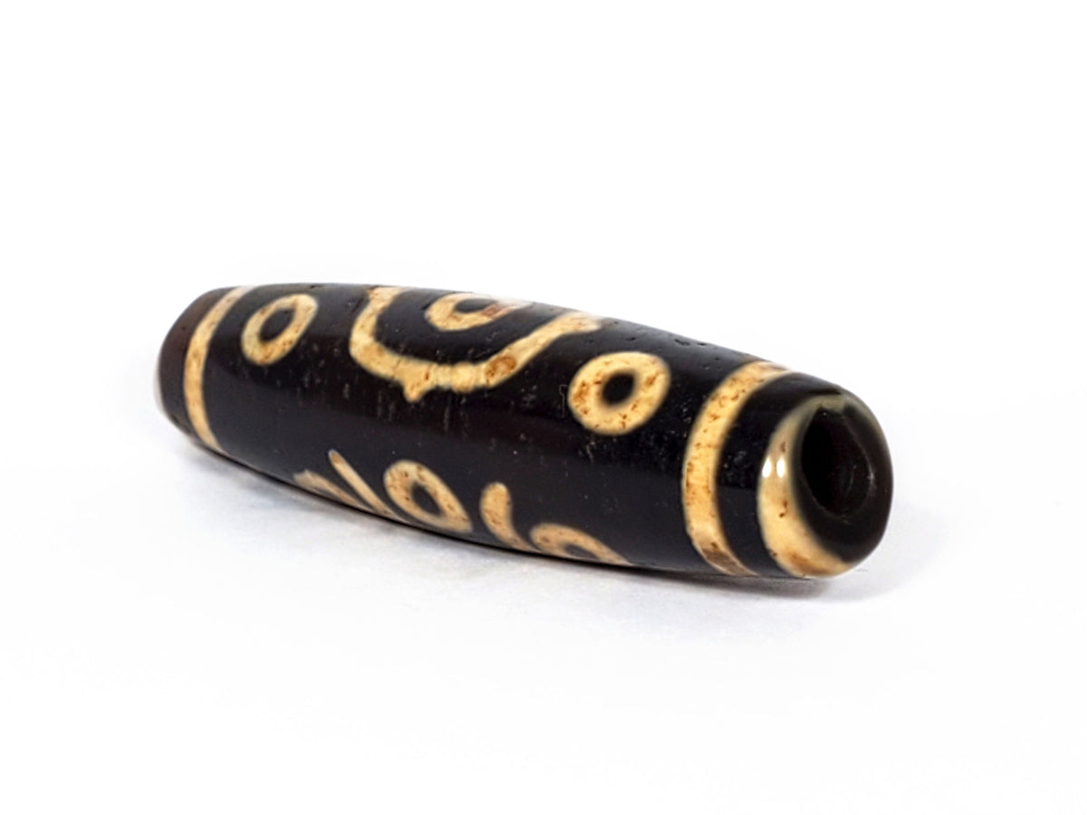V-FA-062126-14E-LK dzi bead, angled view showing large keyhole drill hole, unretouched