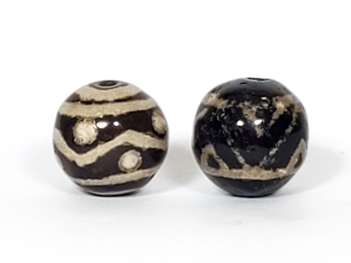 V-FA-062526-TSWS-TT pair round agate dzi, front view, black ground, sandy-cream motifs, 13.8×13.7 & 13.6×13.2mm, unretouched
