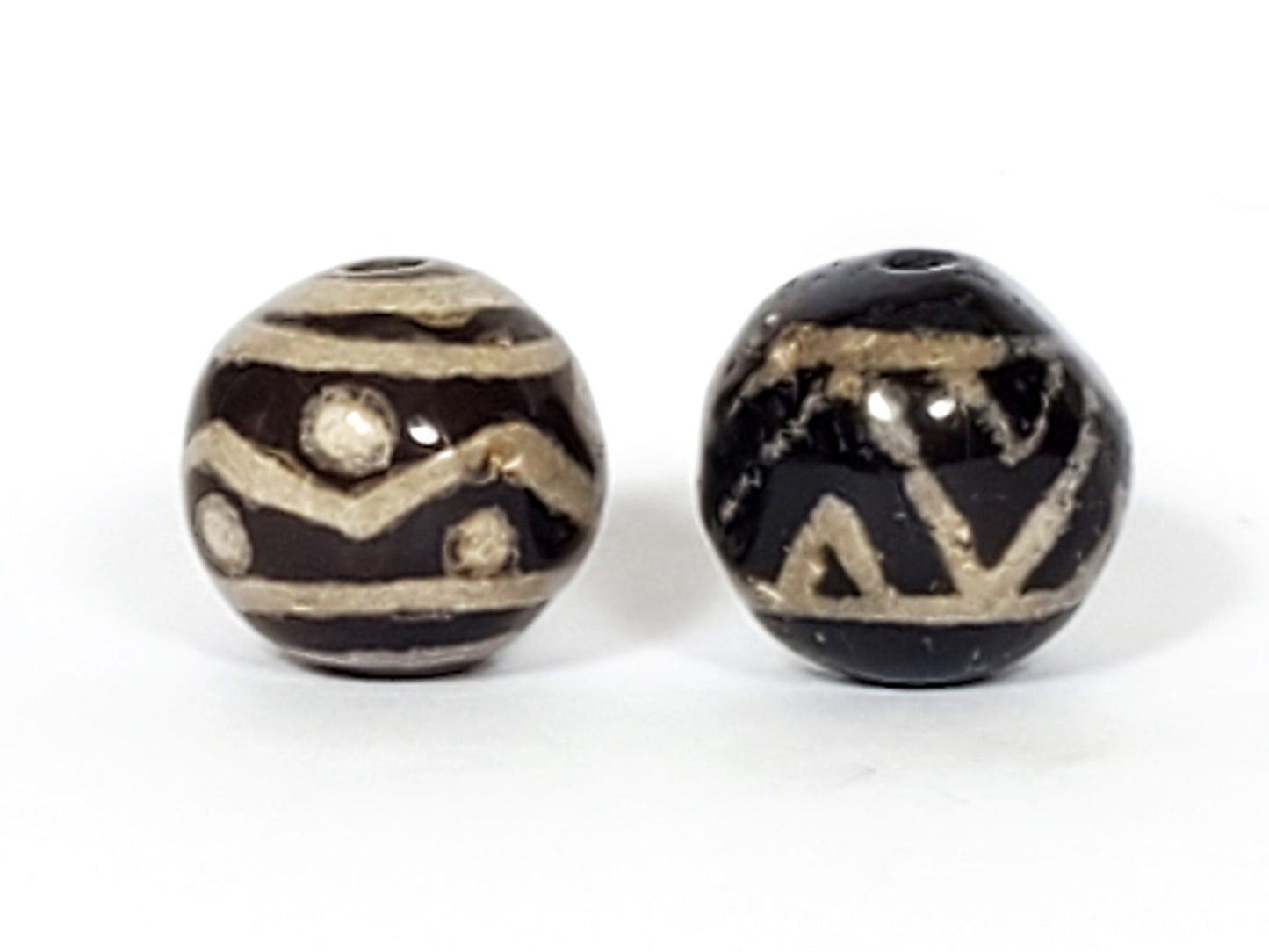 V-FA-062526-TSWS-TT Bead A tiger stripe wave star, Bead B tiger tooth wave, side view, black ground, sandy-cream, unretouched