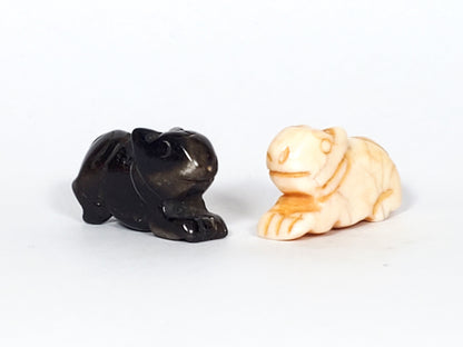 Antique Tibetan carved marmot beads, black and cream bone, pair with detailed facial features and drill holes