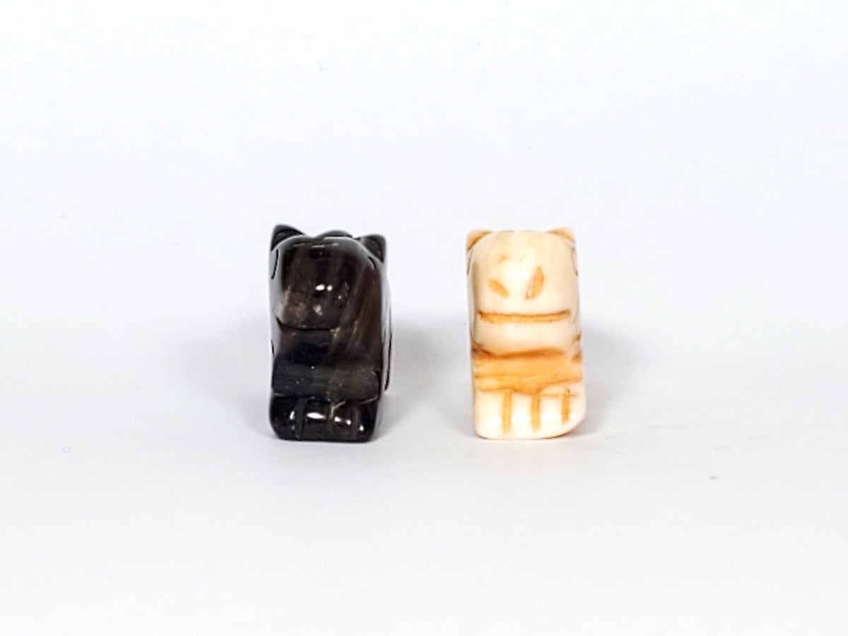 Antique Tibetan carved marmot beads, black agate and cream bone, with detailed facial features and drill holes