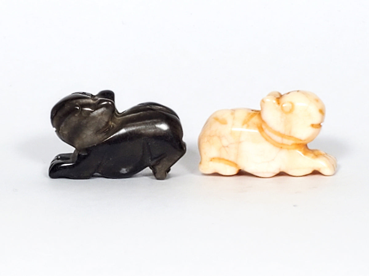 Pair of antique Tibetan carved marmot beads in black agate and cream stone with details