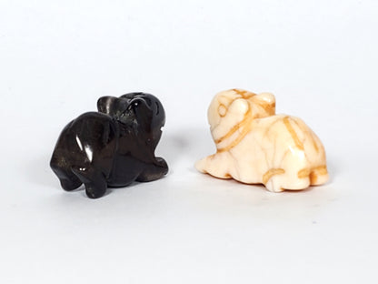 Pair of antique Tibetan carved marmot beads in black and cream agate with natural patina