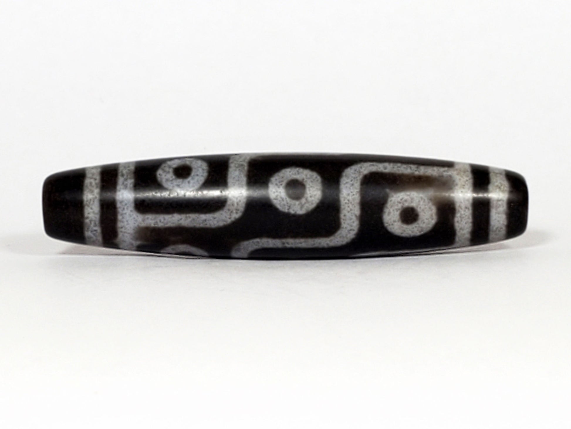 N-062226-9E, nine eye agate dzi, 57.7×12.9mm, deep cool grey-black, silvery-grey motif, face A, unretouched