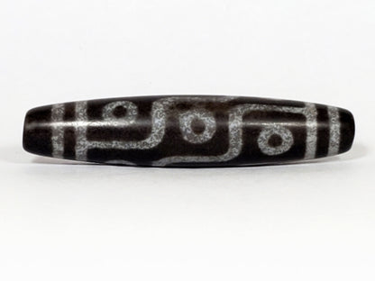 N-062226-9E, face C, nine eye dzi, cool dark grey-black agate, three eyes visible, asymmetric fusiform, unretouched