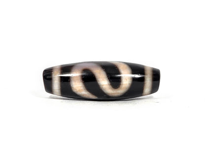 Antique Tibetan money hook dzi bead AT-B-101226-MH, first lateral profile showing cream-white S-curve money hook motif with warm amber bloodspot tones on pitch-black agate ground, 100–300 years old