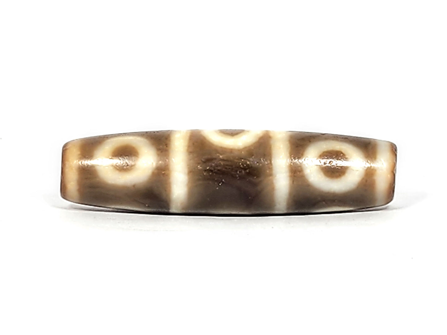 Fourth face of ancient Eight Eye Dzi — three eyes with cream stripe dividers, smooth warm agate