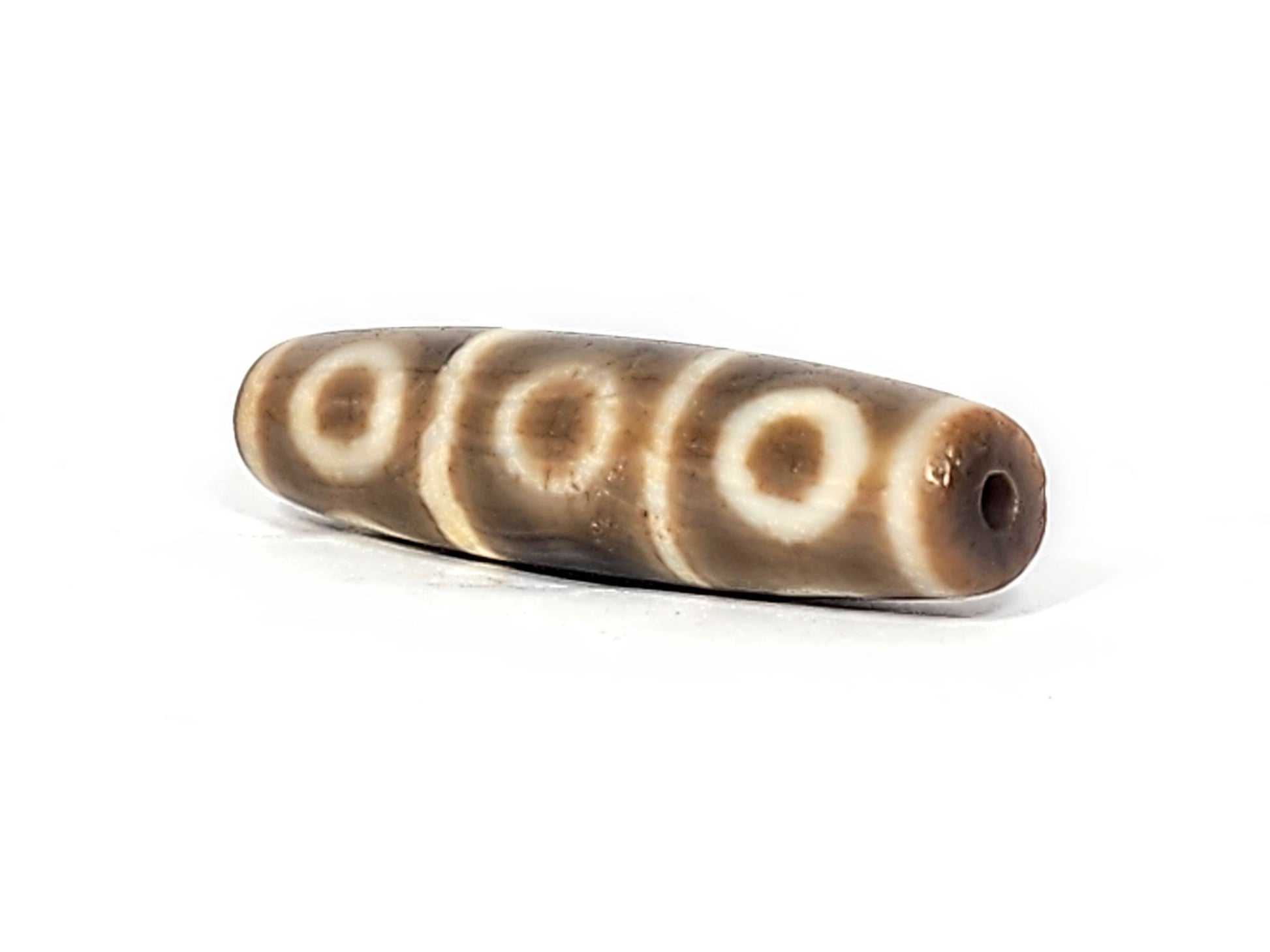 Second end of ancient Eight Eye Dzi — drill hole and amber agate at tip, graceful tapered profile