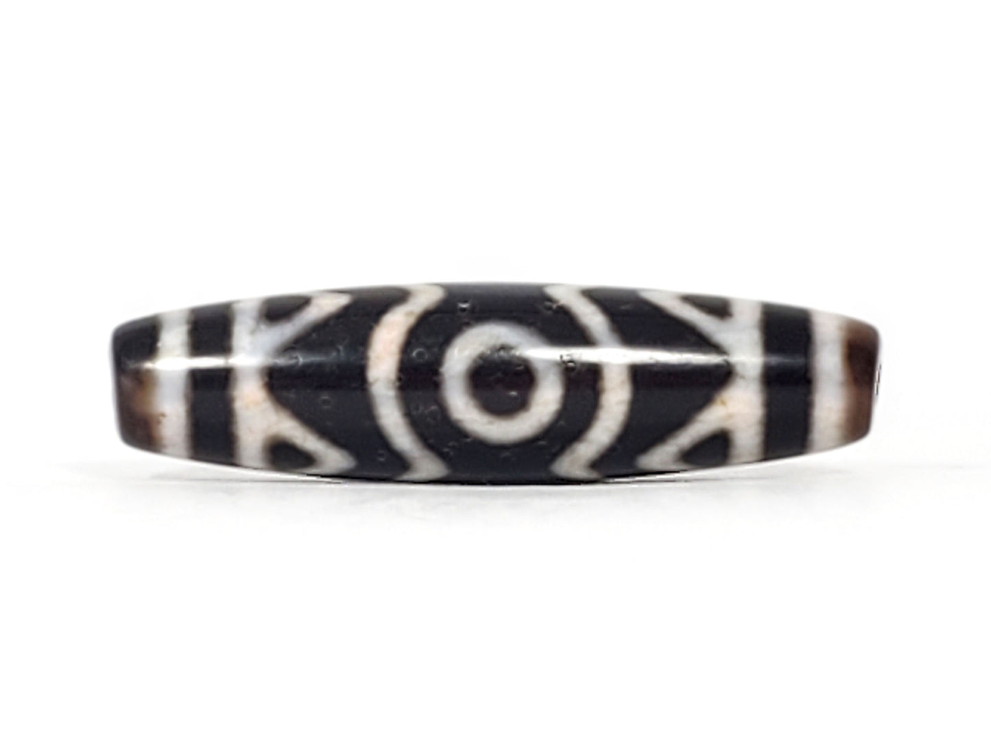 Third angle of ancient Three Eye Dzi bead — all three eye circles visible across 48mm length, tiger tooth etching alongside, unretouched