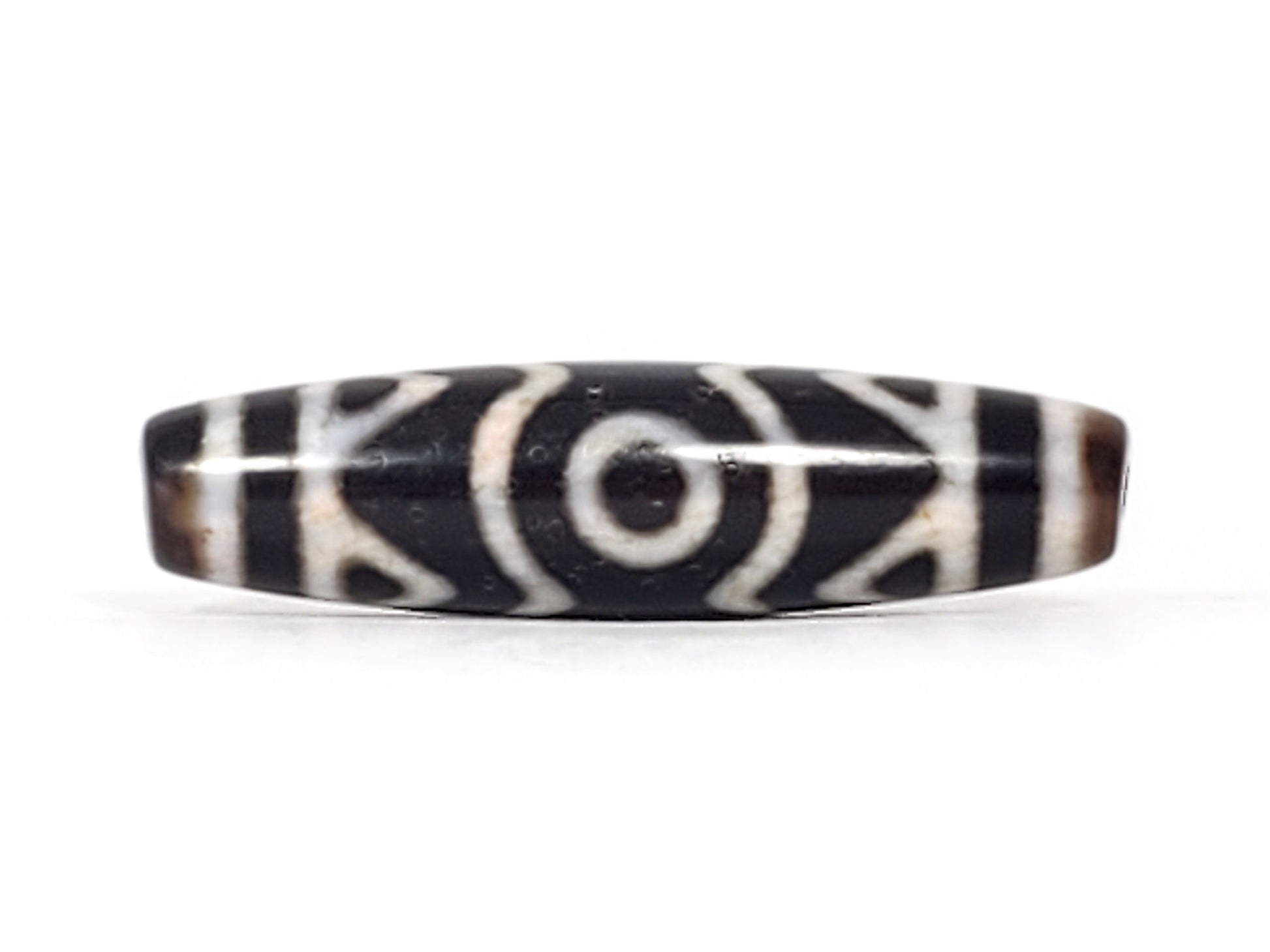 Third angle of ancient Three Eye Dzi bead — all three eye circles visible across 48mm length, tiger tooth etching alongside, unretouched