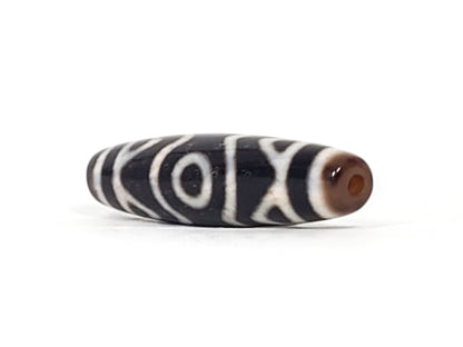 Ancient Three Eye Dzi bead showing deep red vermillion cinnabar bloodspot clearly visible at bead end, 500+ years old