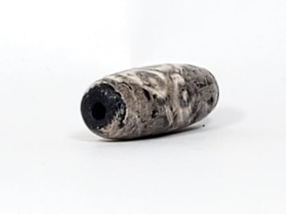 Angled end of ancient Twelve Eye Lotus Dzi — drill hole visible, calcification wraps to tip