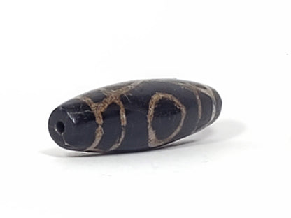 End view of ancient Two Eye Dzi bead showing drill hole and natural agate banding — 1,500–2,000 years old, unretouched