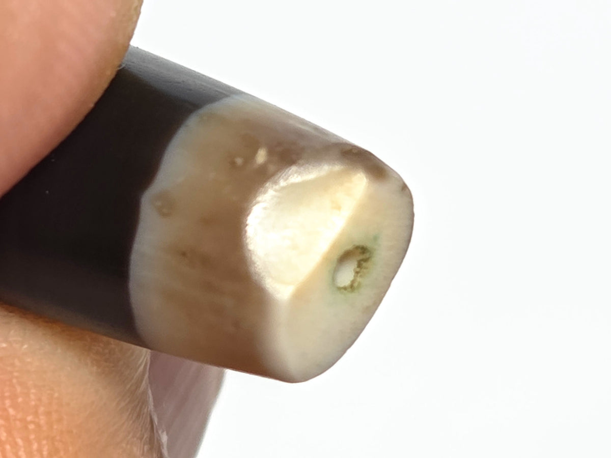 Ac-061526-1SBW, Face C, pitch-black ridge on dark body, bright highlight line, pale translucent end caps, unretouched