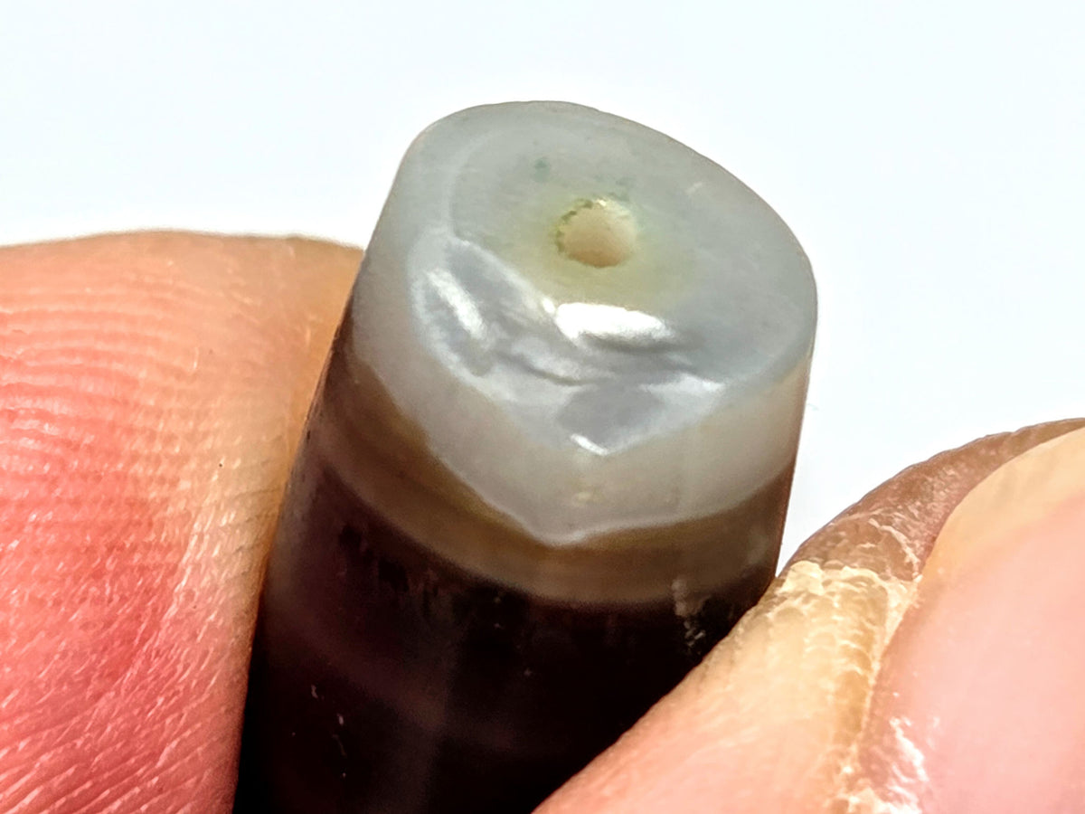 Ac-061526-1SBW, left end 3/4 view, drill hole, translucent pale grey-white end cap, honey-brown transition, unretouched