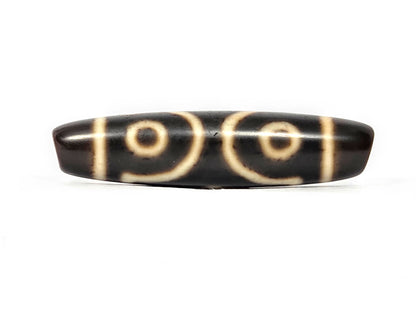 Opposite side of ancient Tibetan Three Eye Dzi bead — cream eye motif etching visible on dark natural agate, 500+ years old