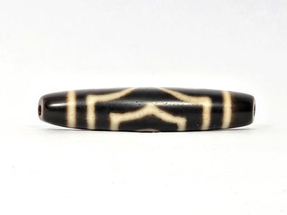 Three-quarter angled view of ancient Three Eye Dzi bead — 51.5mm natural agate showing depth of etched eye circles
