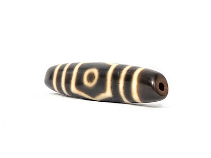 End view of ancient Tibetan Three Eye Dzi bead showing drill hole and natural agate banding — unretouched photograph