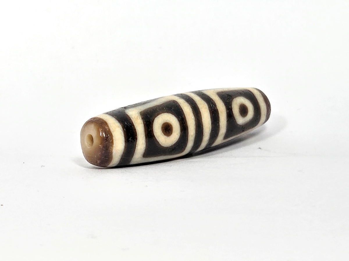 Ac-080425-4E macro left shoulder, cream stripe bands and square eye frame edge, age surface texture disclosed, unretouched