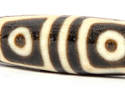 Ac-080425-4E macro right end, drill hole and square-framed eye detail, warm honey-brown end cap, unretouched