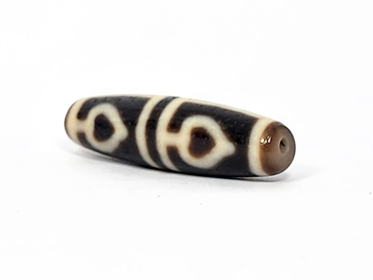 Ac-070625-FLB3 left drill hole end, sandy-tan tip and drill interior, bodhi leaf curves visible from end, unretouched