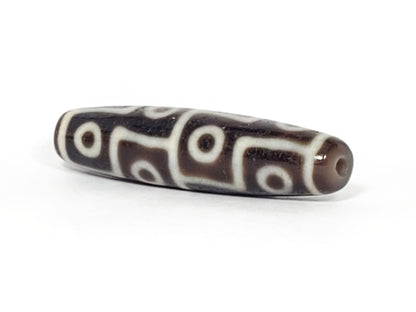Ac-061826-12E2 angled view tip B, warm reddish-brown end cap, clean drill hole, unretouched