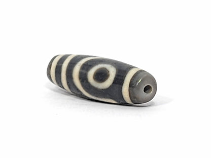 Ac-052525-2E left drill hole end, cool grey-brown tip, concentric ring eye visible from end angle, unretouched