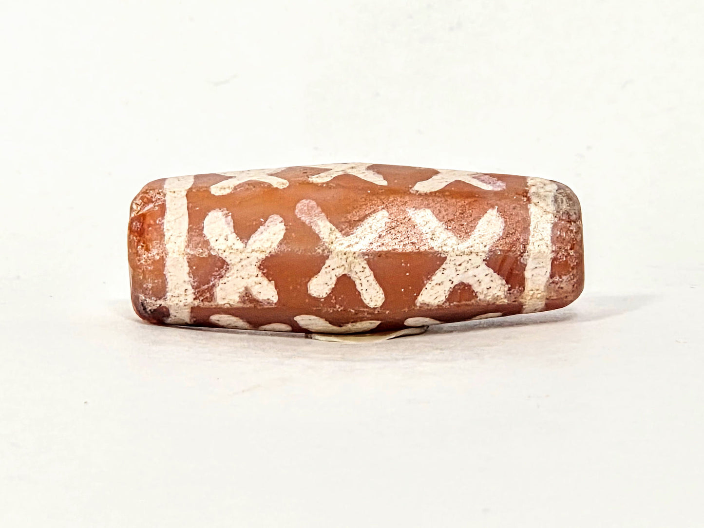 Ac-062426-12X ancient twelve X-cross carnelian dzi 28.5x11.0mm fourth face broad barrel form unretouched