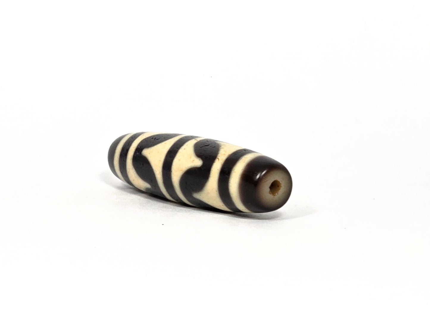 At-090226-DW8 antique double wave dzi cream black agate angled view drill end warm brown cap, unretouched