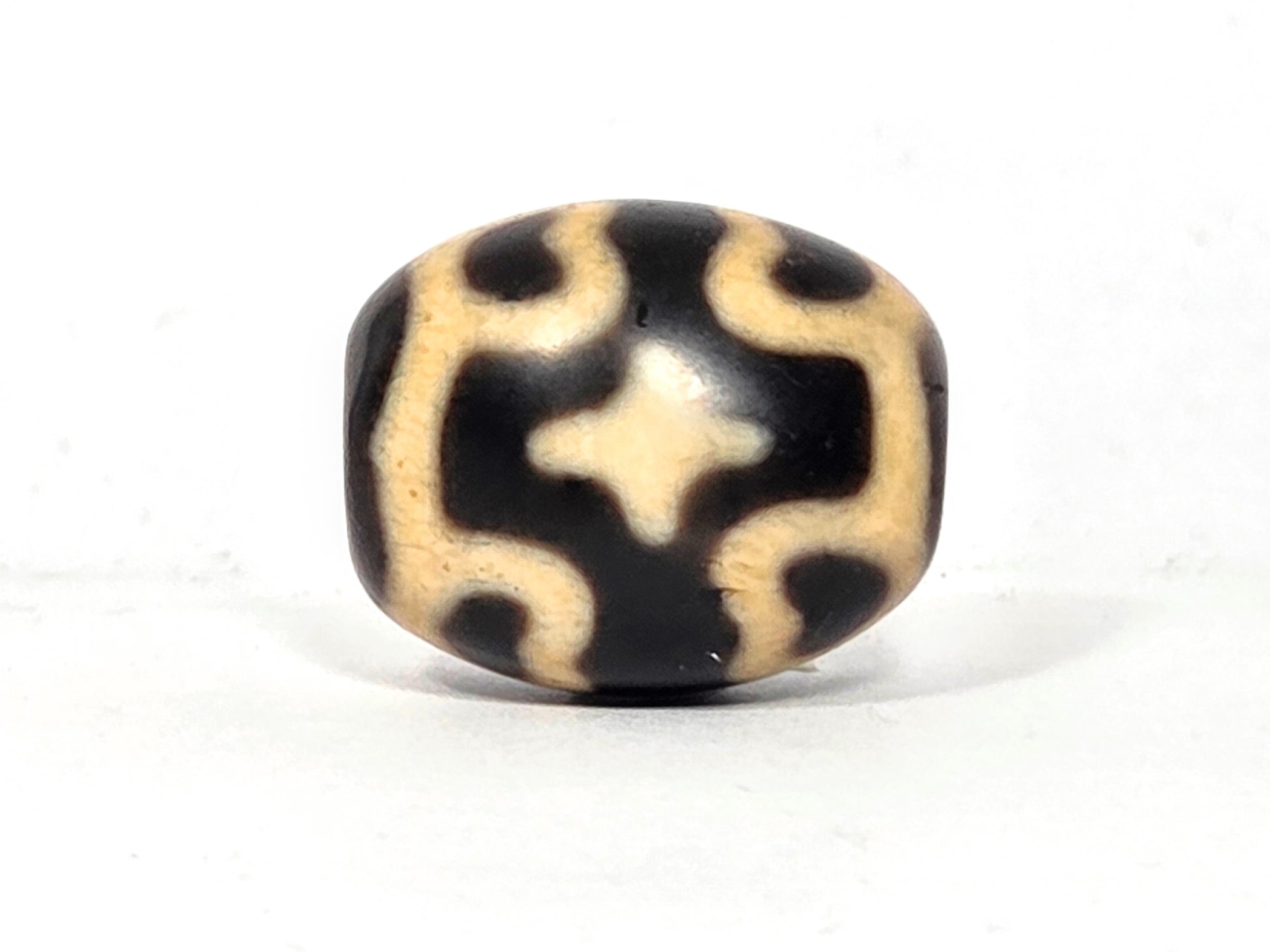 Black and beige bead with six eye lotus and cross pattern on agate