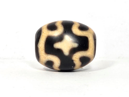 Black and beige bead with six eye lotus and cross pattern on agate