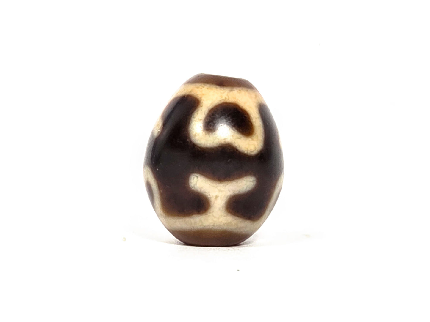 At-080926-4ELT antique round dzi bead 19.9×16.6mm, rotation D showing scroll-form upper element and curved treasure vase arms below, unretouched