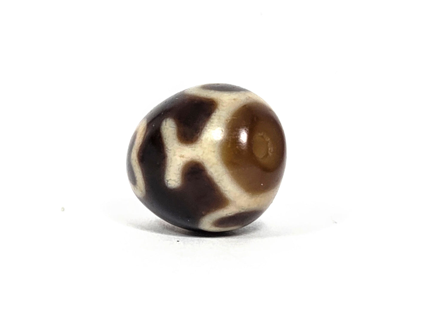At-080926-4ELT antique round dzi bead 19.9×16.6mm, rotation E side view showing cream cross element and warm translucent drill end zone, unretouched