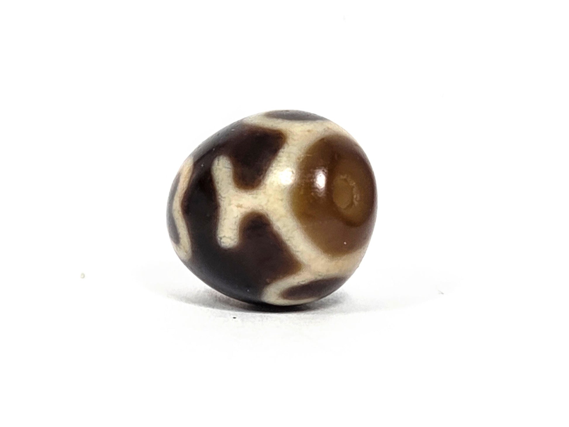 At-080926-4ELT antique round dzi bead 19.9×16.6mm, rotation E side view showing cream cross element and warm translucent drill end zone, unretouched