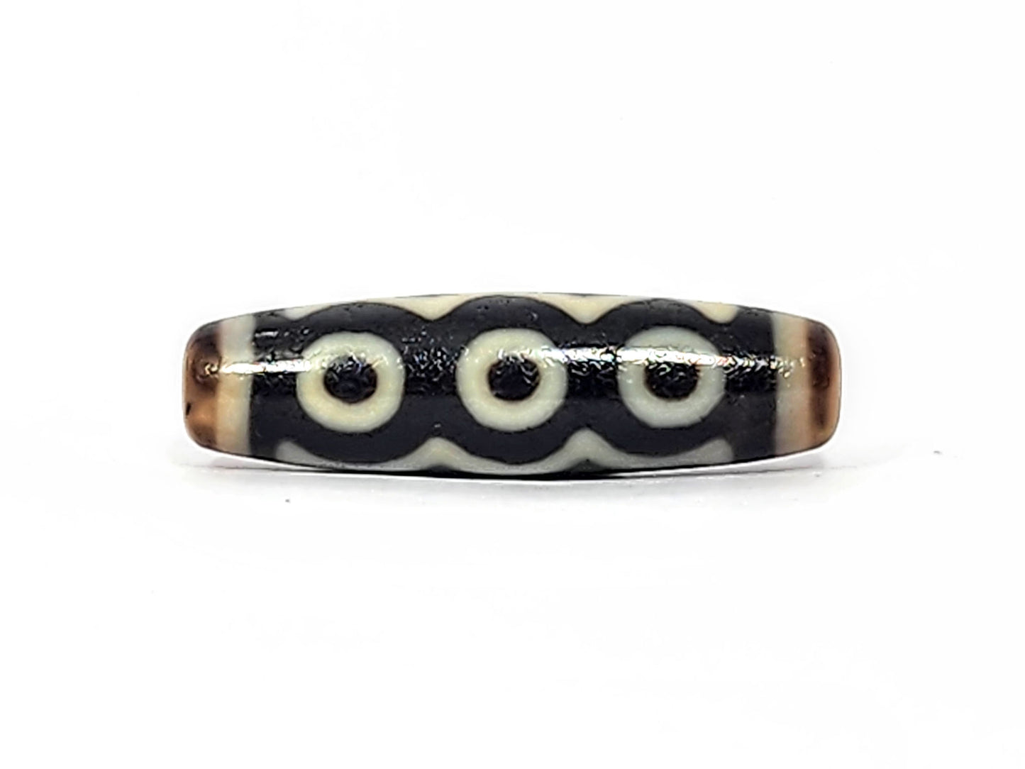 Face C of antique five eye dzi At-072625-5E, three cream eye rings linked by continuous arc on pitch-black agate, colonnade composition, 44.5mm, unretouched photography