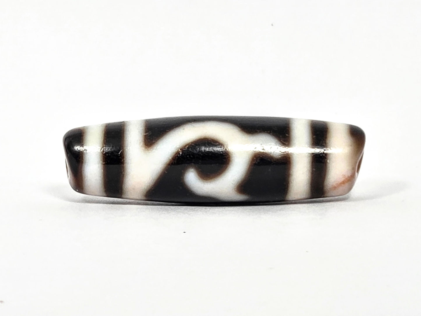 At-080426-GTBS antique Green Tara dzi bead 37.9×11.0mm, turn view showing scroll motif continuing around shoulder, cream-peach bloodspot zones, unretouched