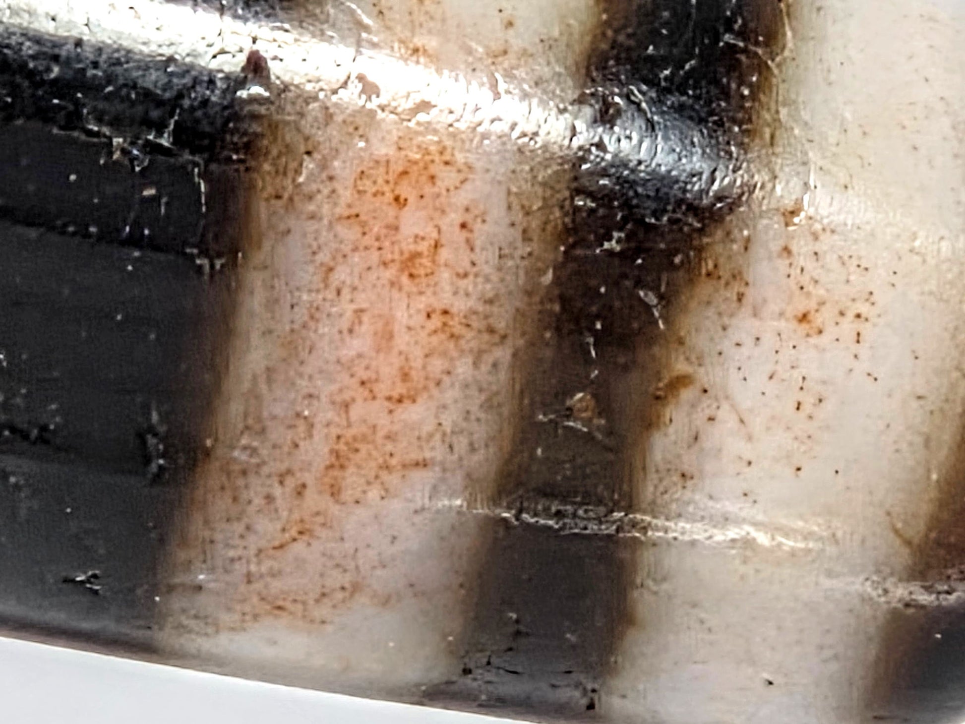 At-080426-GTBS macro view showing pervasive reddish-orange cinnabar bloodspot saturation in cream zone between stripe borders, unretouched