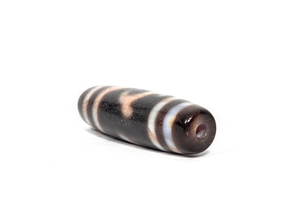 At-080426-GTBS2 antique Green Tara dzi bead 37.8×10.8mm, angled drill-end view showing warm dark brown agate end cap and fusiform taper, unretouched