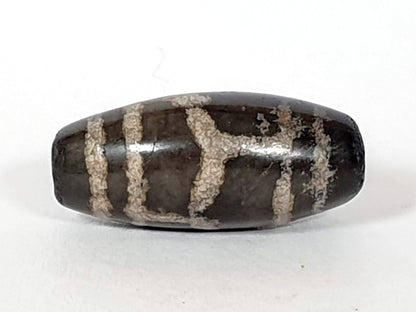 Antique Tibetan dzi bead longevity motif, dark brown agate, white etched pattern, aged patina, oval barrel shape