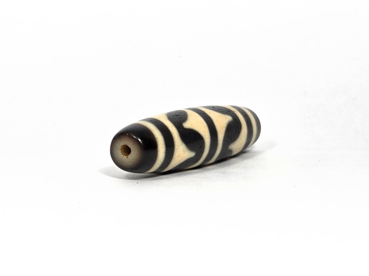 At-090226-DW8 antique double wave dzi cream black agate angled view drill end warm brown cap, unretouched