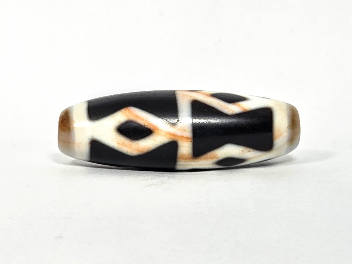 At-062126-6DE dzi bead, angled side profile, black ground and white dividers, unretouched