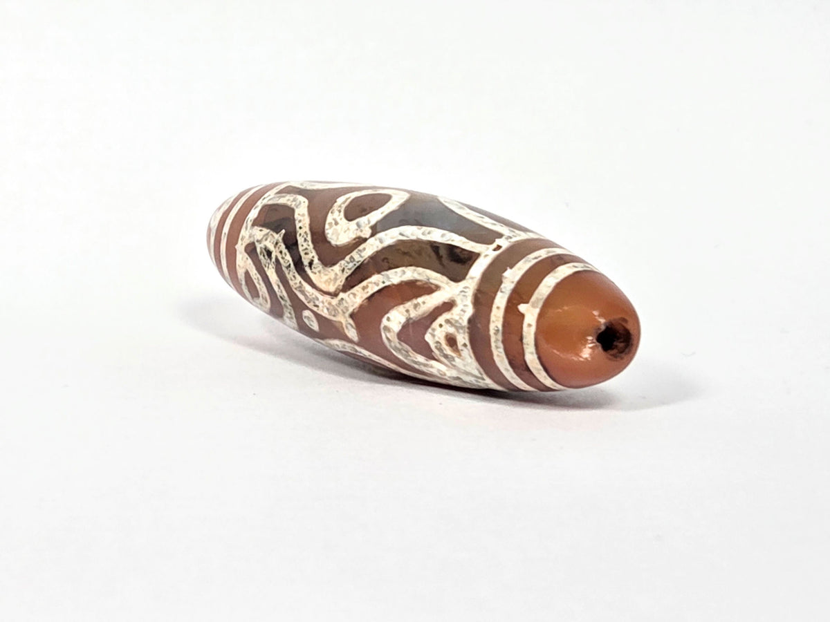 At-061426-2ETTSt carnelian dzi, intact left end cap, terracotta-red tip, clean drill hole, hairline disclosed, unretouched