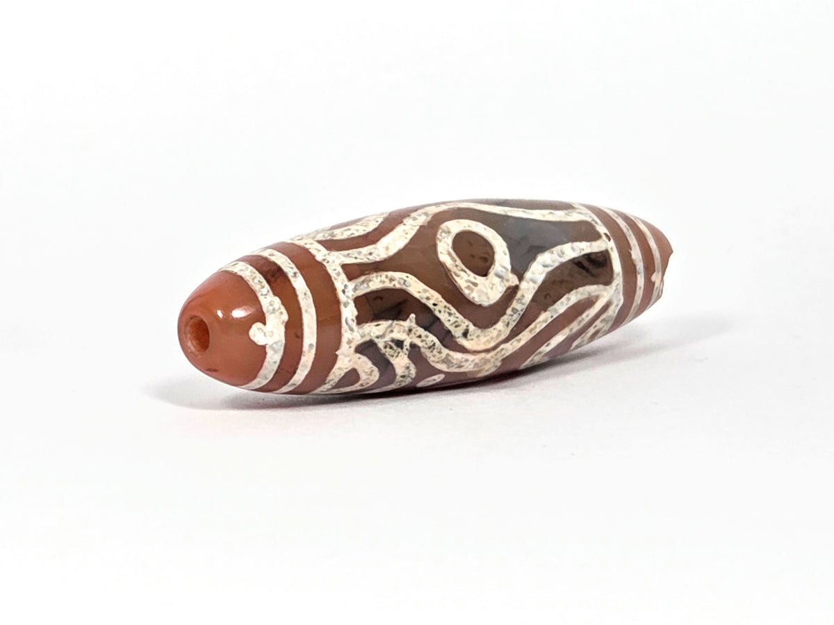 At-061426-2ETTSt carnelian dzi, RIGHT END CHIP DISCLOSED — concave impact chip at tip, drill hole intact, unretouched
