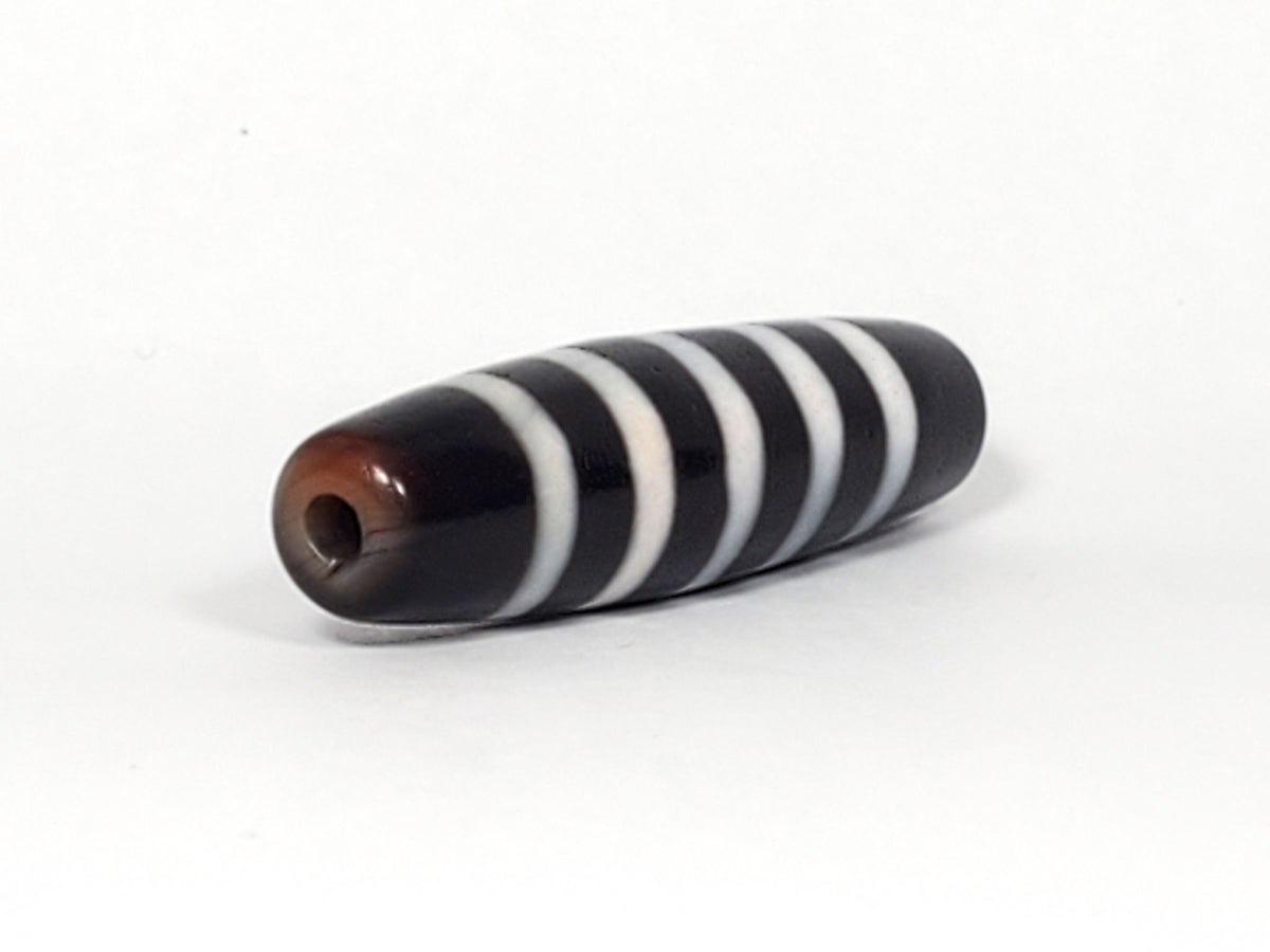 At-110223-9SBS, right tip drill hole, pitch-black end cap, five stripe bands visible wrapping tip, unretouched