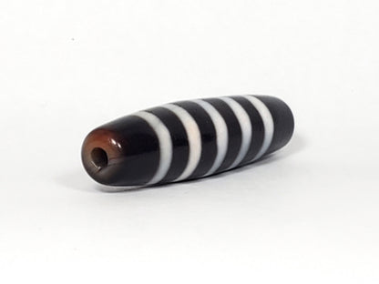 At-110223-9SBS, right tip drill hole, pitch-black end cap, five stripe bands visible wrapping tip, unretouched
