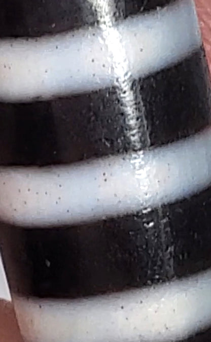 Antique nine-stripe chung dzi bead, pitch-black agate, white bands, visible bloodspots, aged patina, 44.7mm